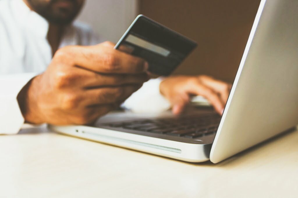 man with credit card using laptop