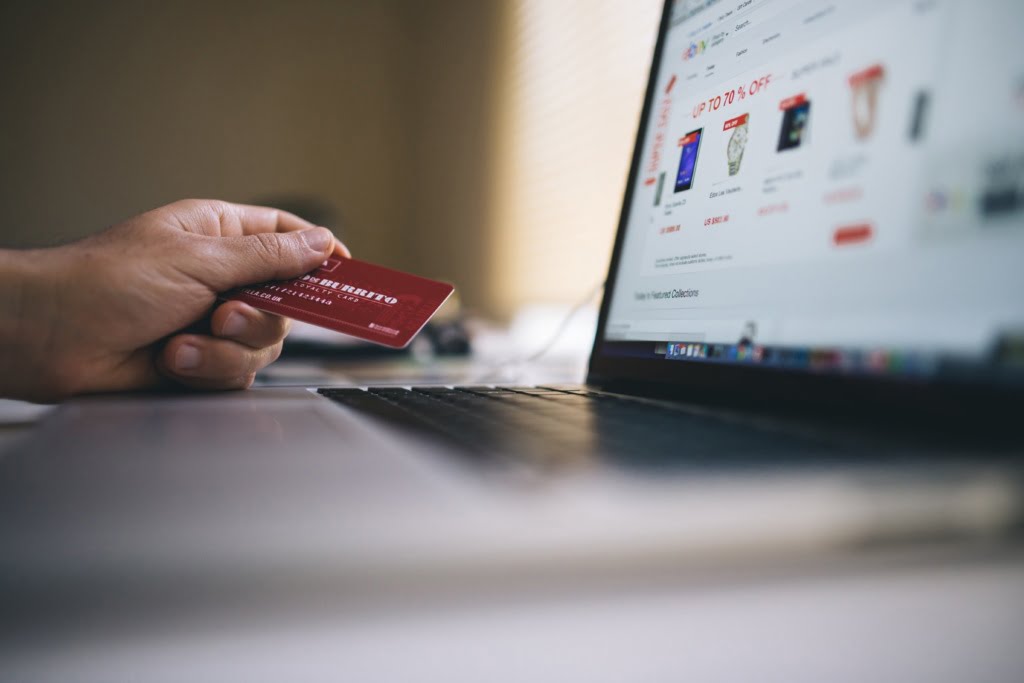 person with credit card using laptop